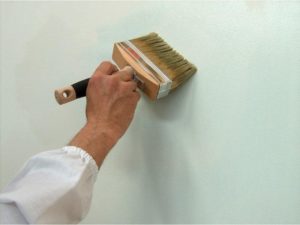 Обрабатывают поверхности стен грунтом