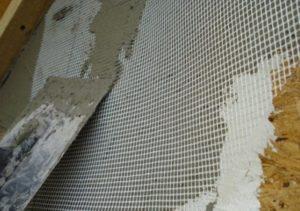 При нанесении штукатурки поверхность стены покрывается армирующей сеткой
