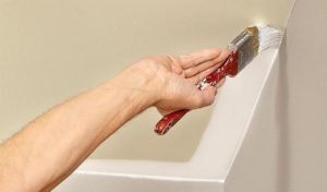 Промазывают углы широкой малярной кистью